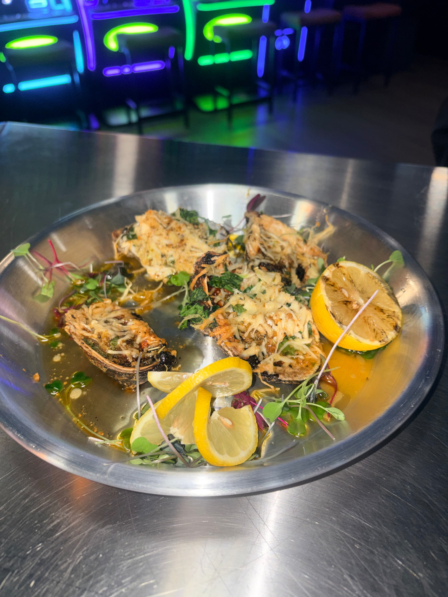 Baked oysters with charred lemon and micro greens at Olivia 91
