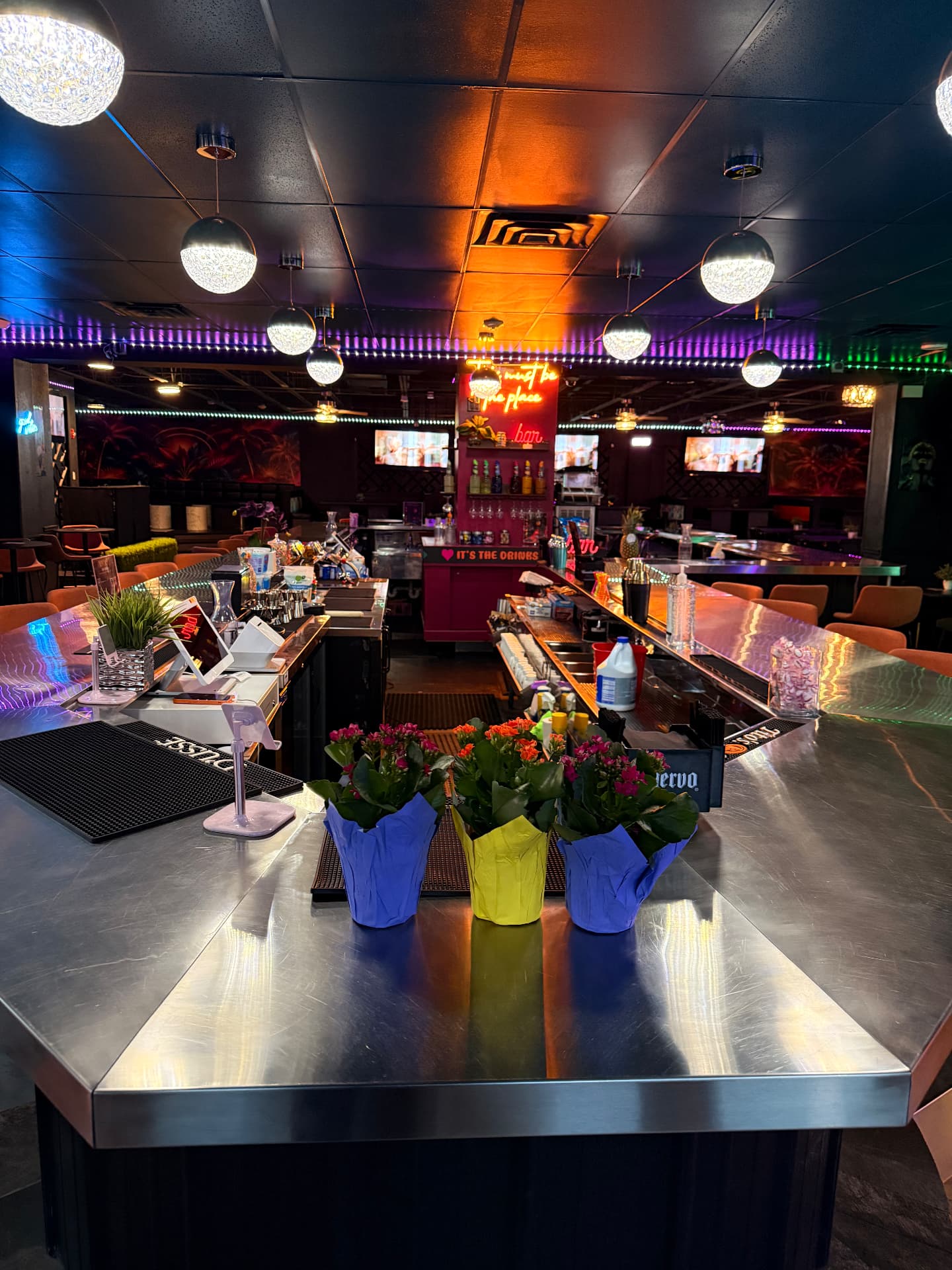 The main bar at Olivia 91 glowing under color-changing lights