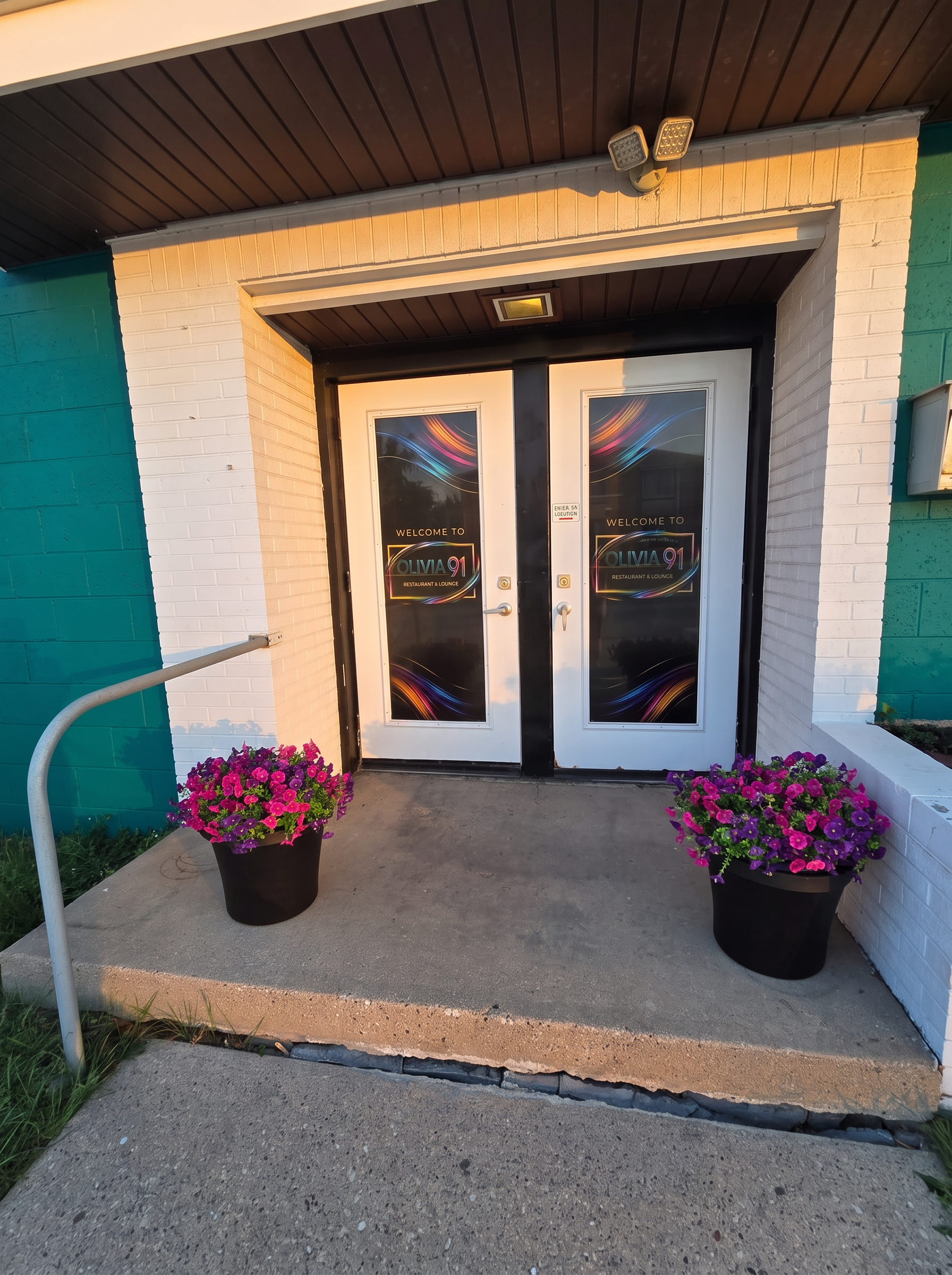 Front entrance doors of Olivia 91 with welcome decal and flowers